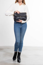 Donna che tiene La Busta, pochette donna in pelle nera con borchie