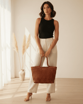 Donna che indossa una borsa tote intrecciata in pelle color cuoio