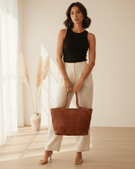 Donna che indossa una borsa tote intrecciata in pelle color cuoio