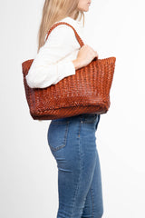 Borsa tote intrecciata La Toscana in pelle color cuoio portata a mano