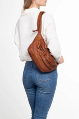 Borsa a tracolla in pelle intrecciata color cuoio indossata sulla spalla da donna